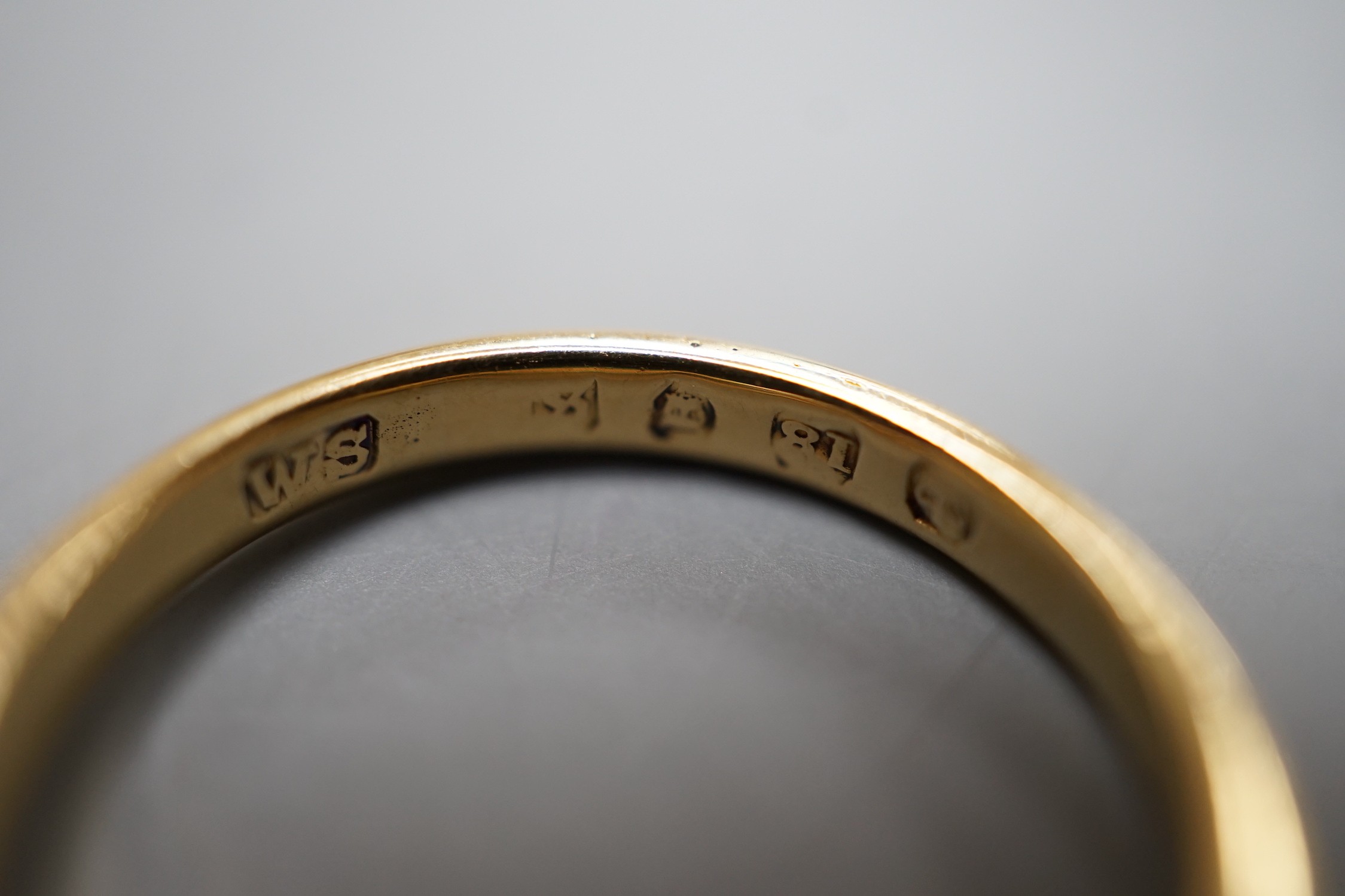 An 18ct gold, three stone ruby and two stone diamond set half hoop ring, size O, gross weight 3.7 grams.